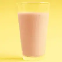 fotografia em tons de laranja e rosa tirada de um copo transparente com a bebida