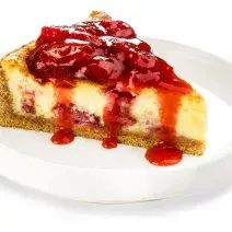 Fotografia em tons de vermelho em um fundo branco com um prato branco fundo ao centro com uma fatia da cheesecake de morango.