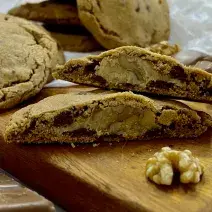 Foto da receita de Cookies recheados de nozes. Na foto observa-se cookies dispostos sobre uma tábua de madeira.