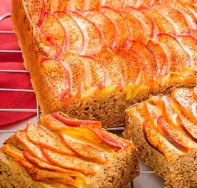 Bolo de maçã coberto de fatias de maçã polvilhadas com canela. Bolo de maçã coberto de fatias de maçã polvilhadas com canela.