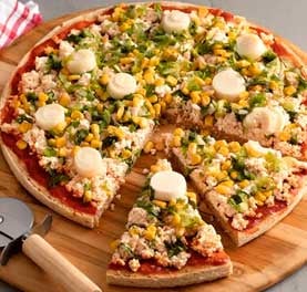 Pizza coberta de ricota, milho, espinafre e palmito sobre tábua de madeira. Pizza coberta de ricota, milho, espinafre e palmito sobre tábua de madeira.