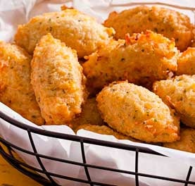 Cestinha forrada com papel e cheia de bolinhos de arroz fritos. Cestinha forrada com papel e cheia de bolinhos de arroz fritos.