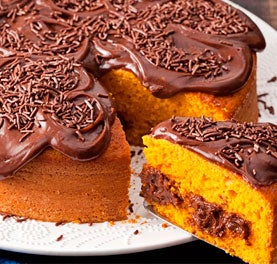 Bolo de cenoura com cobertura e recheio de chocolate com uma fatia cortada. Bolo de cenoura com cobertura e recheio de chocolate com uma fatia cortada.