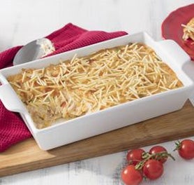 Travessa branca retangular com fricassé de frango coberto por batata palha. Travessa branca retangular com fricassé de frango coberto por batata palha.