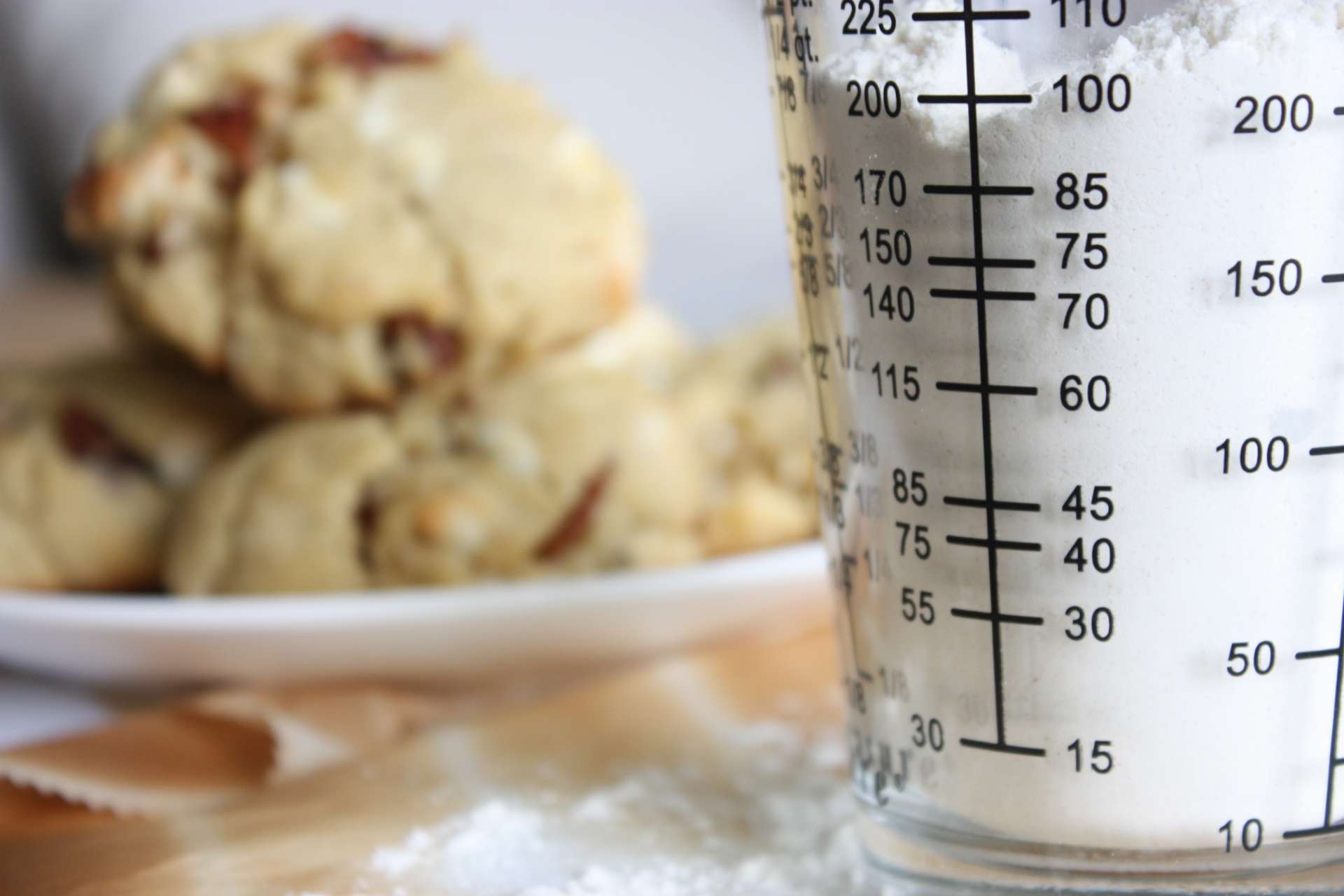Medidas para os ingredientes na cozinha: copo com medida e atrás alguns pães