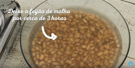 Tigela de vidro transparente com feijão cru de molho em água