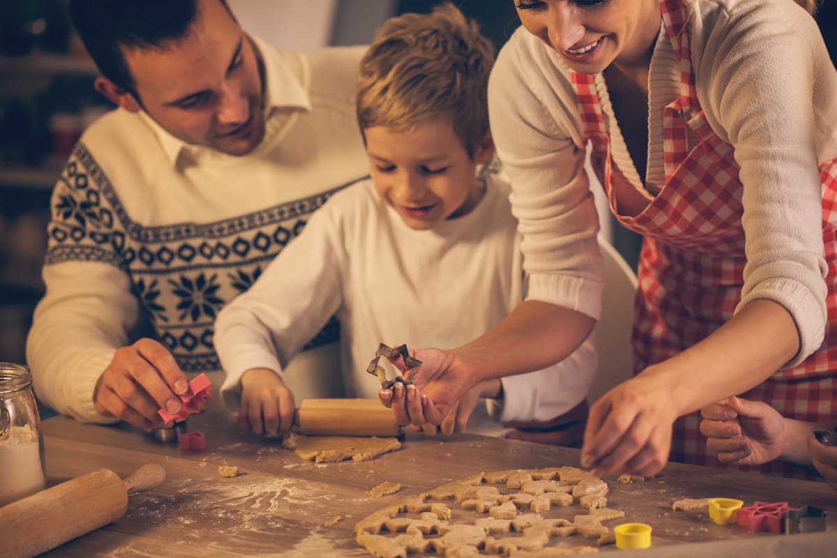 Capa - 15 Sobremesas de Natal para encantar seus convidados! Sobremesas de Natal: uma família preparando biscoitos de natal