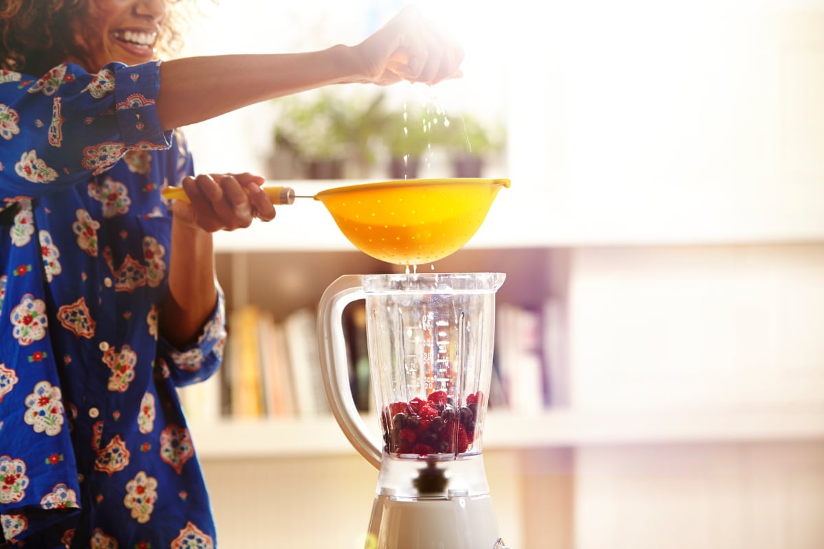 Capa Safra de Fevereiro: 10 bebidas refrescantes com frutas e legumes da estação Safra de Fevereiro: Mulher espremendo limão no liquidificador