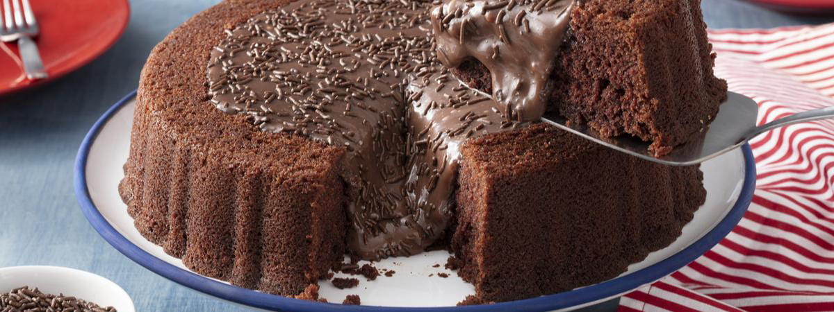 Capa: Dueto Nescau + Moça Dueto Nescau + Moça: Bolo de chocolate com cobertura de chocolate e granulado, com um pedaço sem cortado