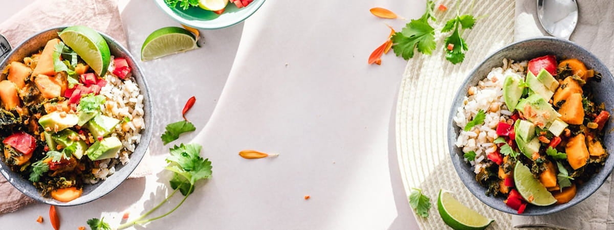 Capa: Dia mundial sem carne Dia Mundial Sem Carne: duas tigelas com arroz e legumes em cada uma delas em cima de uma mesa