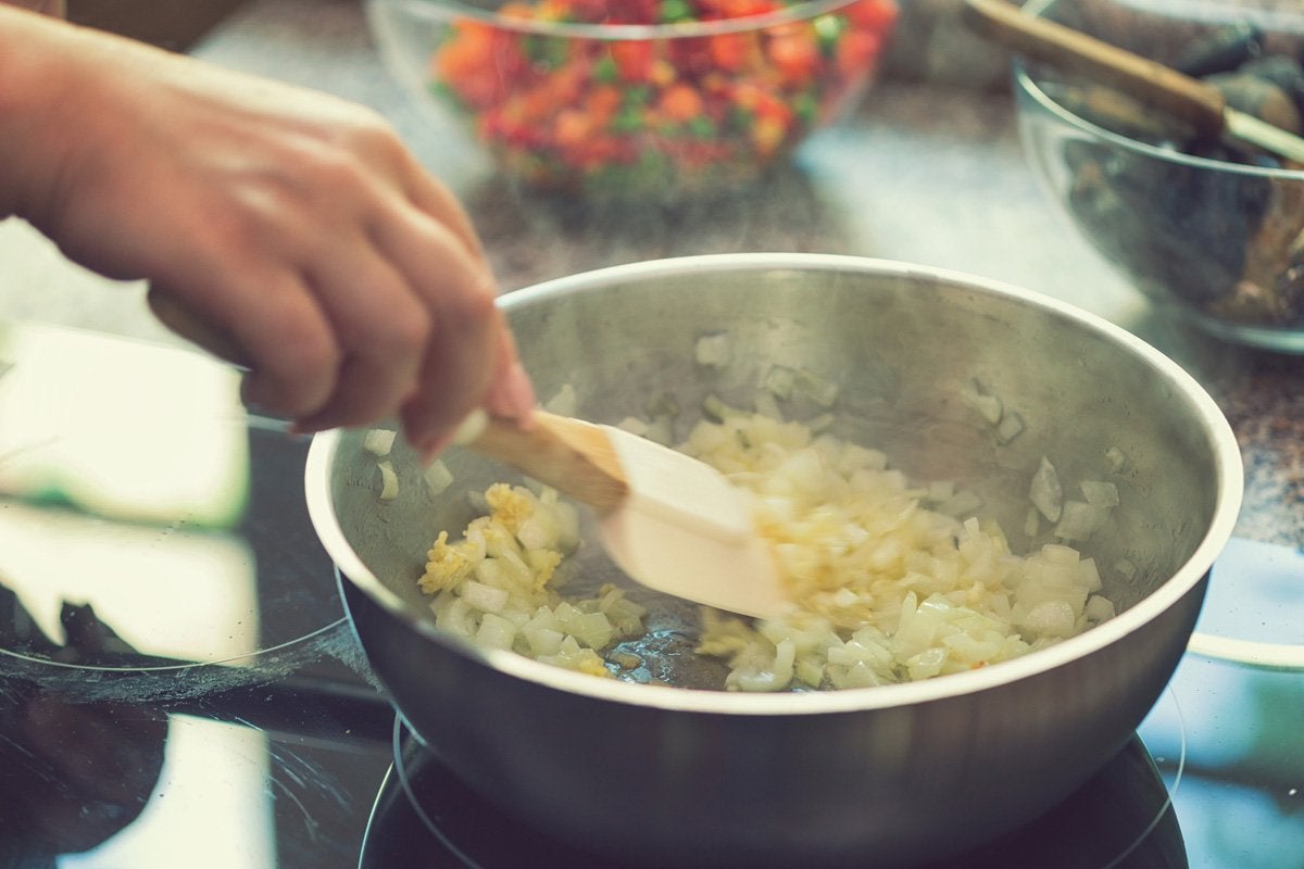 Capa - Cebola: Confira os Principais Benefícios e Receitas Incríveis! Cebola: uma pessoa cozinhando cebola na panela