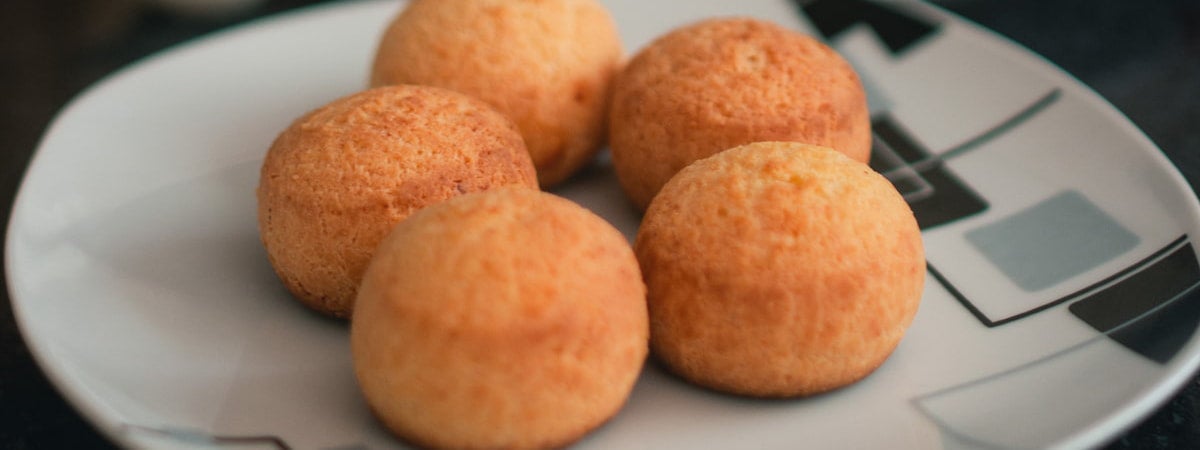 Capa: Pão de Queijo Pão de Queijo: 4 pães de queijo em cima de um prato