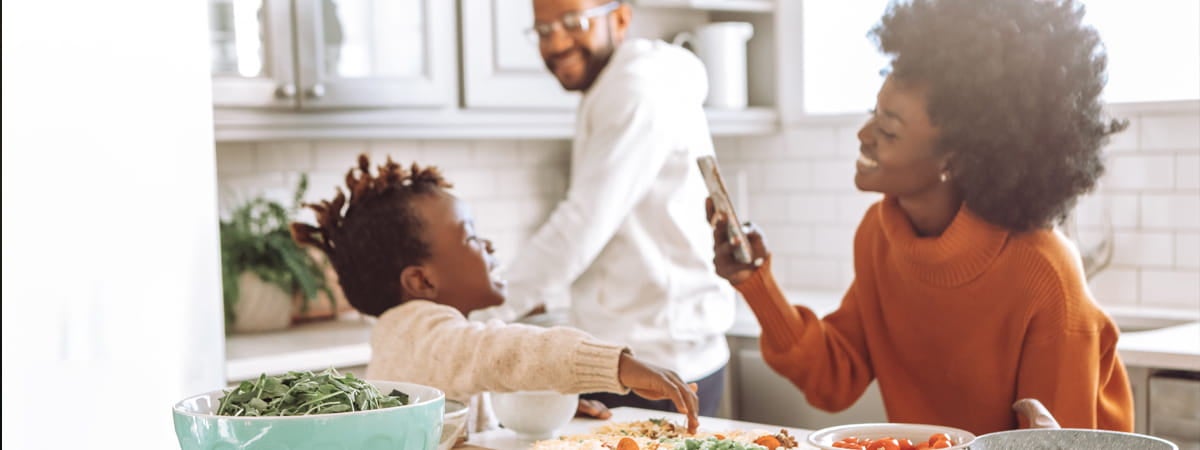 Capa: Receitas para o dia das mães Dia das Mães: Família negra sorrindo na cozinha