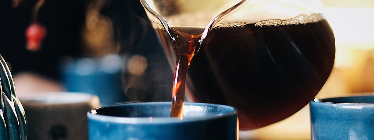 Dia do café: Café em uma jarra sendo derramado em uma xícara
