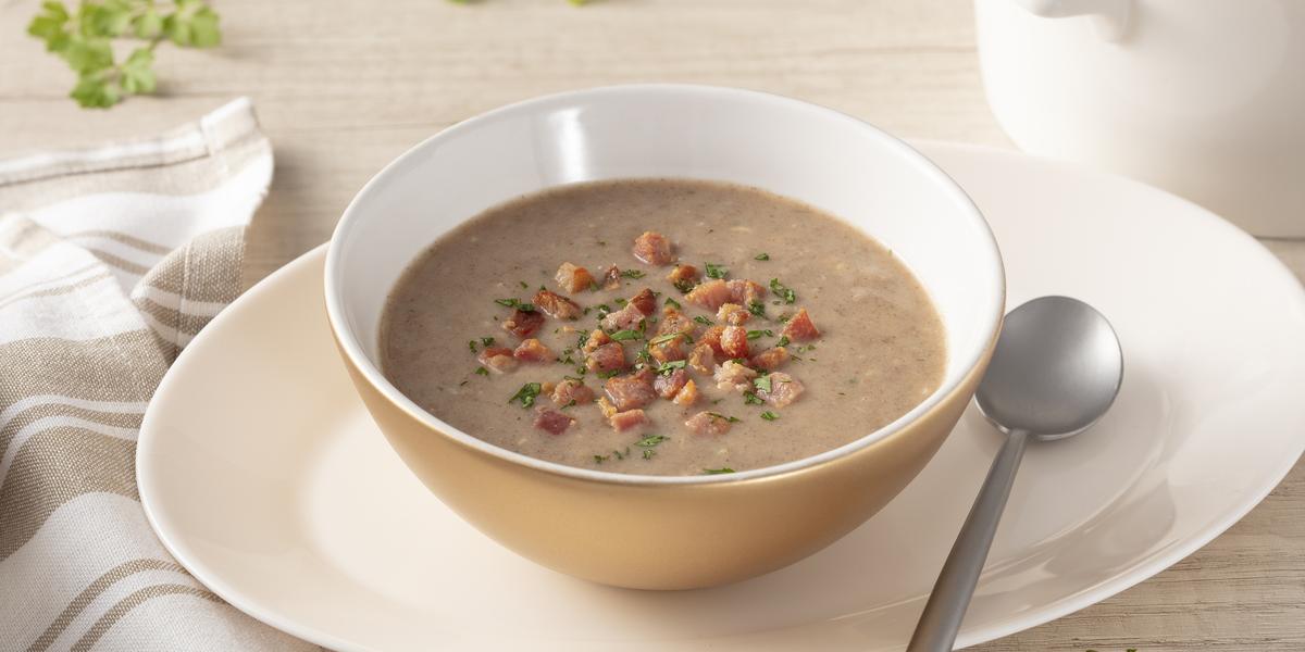 Capa: Comidas de inverno As melhores comidas de Inverno: Sopa de feijão na tigela em cima de um prato, ao lado uma colher