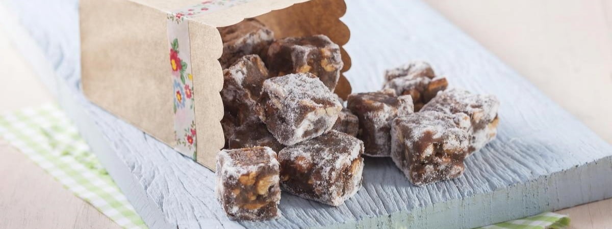 Capa: Dia de Santo Antônio Dia de Santo Antônio: Doce de festa junina em formato de cubo, vários pedaços caídos do pote na mesa