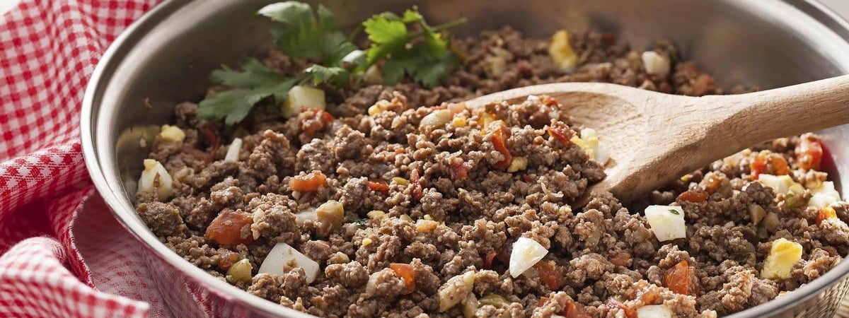 Capa: Janta rápida Dicas de janta rápidaCarne moída em uma panela com uma colher de madeira apoiada dentro