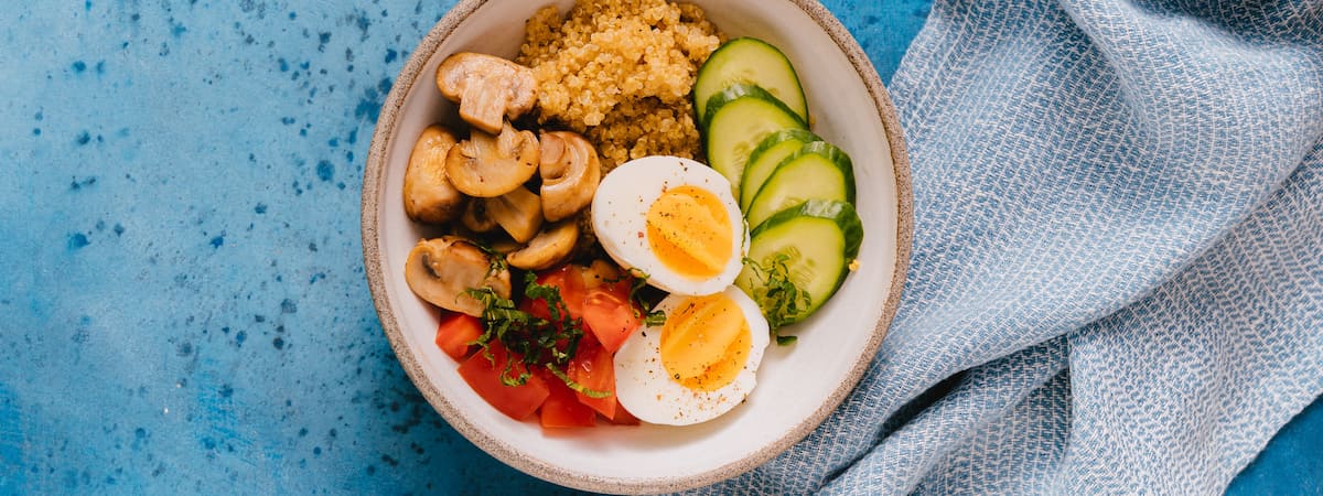 Capa: Ovo Aprenda como cozinhar ovo: Tigela com ovo, picles, tomates, cogumelos, em cima de uma mesa azul