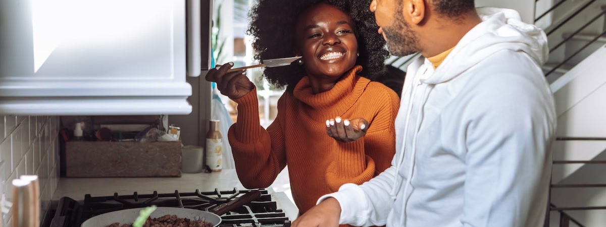 Capa: Utensílios de cozinha para presentear Utensílios Básicos de Cozinha: Mulher negra à esquerda oferecendo comida para o homem negro barbudo à esquerda