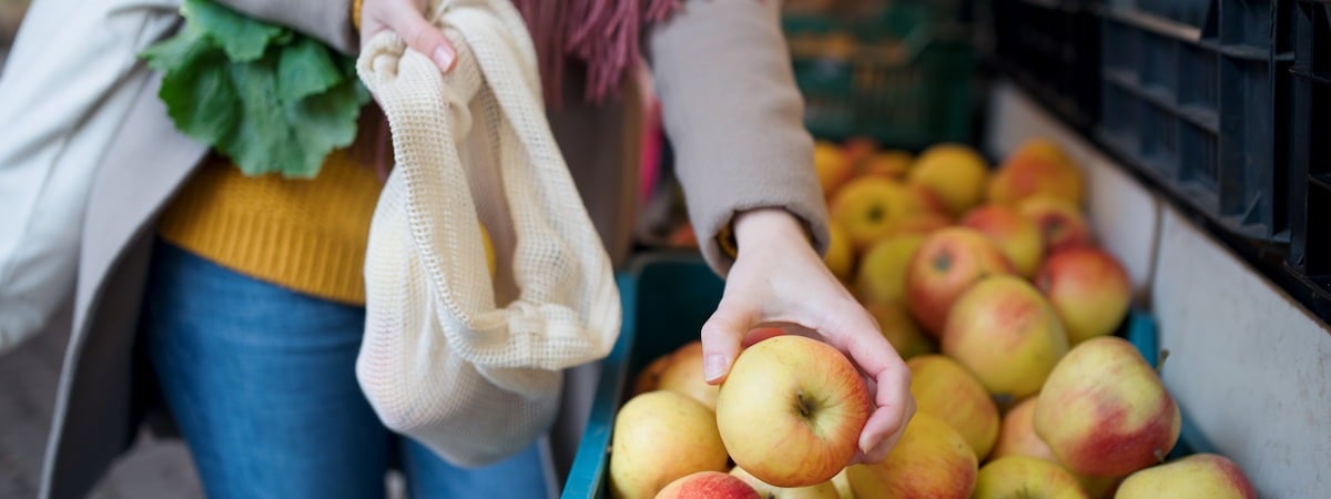 Mulher escolhendo uma maçã Frutas de Junho, Verduras de Junho: Mulher escolhendo uma maçã