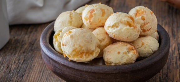 Porção de pães de queijo em bowl sobre mesa de madeira. Porção de pães de queijo em bowl sobre mesa de madeira.