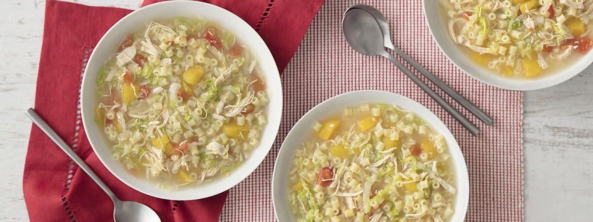 Capa: Sopa de legumes 3 pratos com sopa de legumes e 3 colheres sobre uma toalha vermelha e xadrez (vermelho e branco)