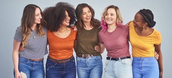 Mulheres de diferentes etnias se abraçando e sorrindo. Mulheres de diferentes etnias se abraçando e sorrindo.