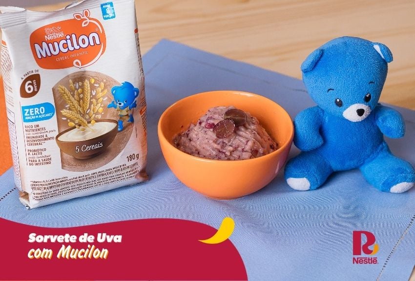 Sorvete de uva com Mucilon em tigela, com embalagem ao fundo e mascote azul ao lado