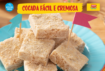 Pedaços de cocada cremosa em prato azul, decorados com bandeirinhas, em destaque Receita Nestlé.