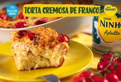 Fatia de torta cremosa de frango em prato amarelo, com tomates e embalagem de Ninho Adulto ao fundo.