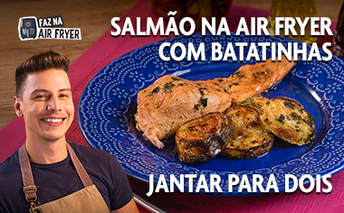 Salmão com batatas preparado na Air Fryer, servido em prato azul, com pessoa ao lado.