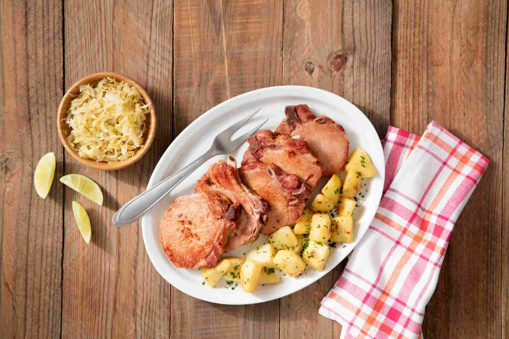 Prato com kassler: carne de porco com batatas e salada de repolho.