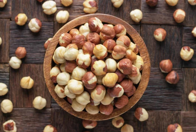 Bowl com avelãs em cima de uma superfície de madeira.