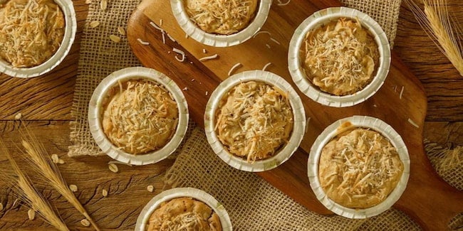 Imagem vista de cima de muffins de banana com coco em forminhas.