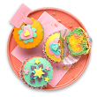 Cupcakes coloridos e decorados sobre um prato rosa.