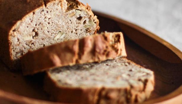 Pão de Liquidificador: Pão com dois pedaços cortados em cima de uma travessa de madeira