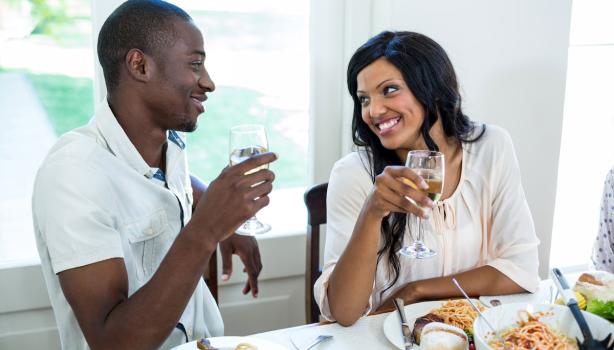 Almoço Romântico:Um homem negro à esquerda com um copo na mão, à direita uma mulher negra com um copo na mão