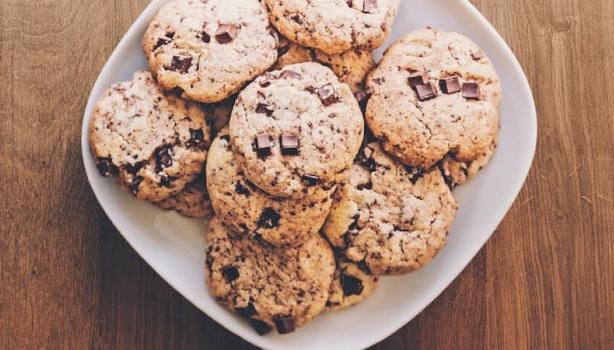 Lanches Rápidos:Vários cookies em um prato, em cima de uma mesa de madeira