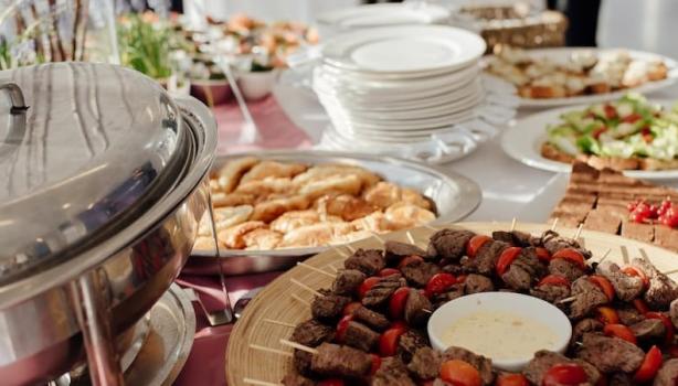 Banquete com espetinhos de carne, torradas, saladas e diversos outros pratos.