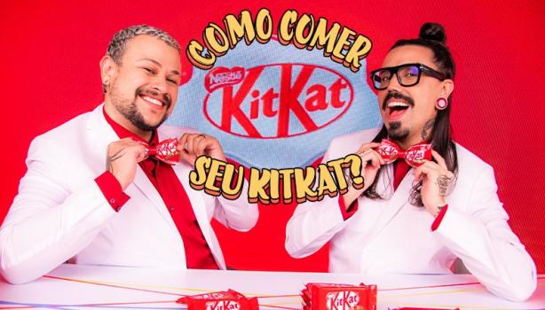 Imagem de dois rapazes vestidos de branco e gravata borboleta vermelha segurando barrinhas de KitKat