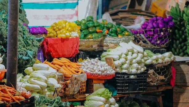 Várias cestas com vegetais dentro delas em uma banca