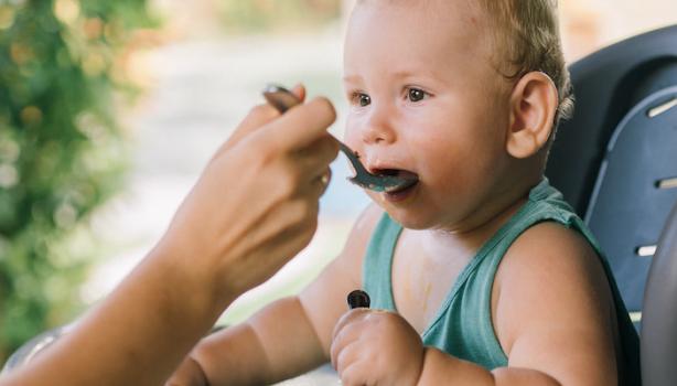 Mãe alimentando o seu filho bebê