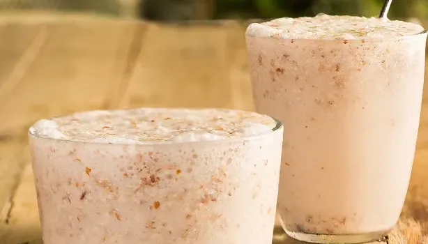 Frappé de Amêndoas com Coco em cima de uma mesa de madeira