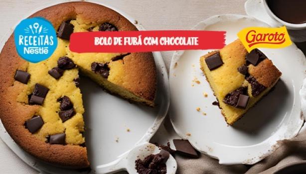 Fotografia mostra um bolo de fubá amarelado com pedaços de chocolates espalhados pela massa.