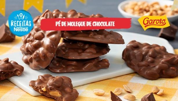 Pé de Moleque de Chocolate Fotografia mostra um doce de amendoim coberto com chocolate espalhados pela mesa.