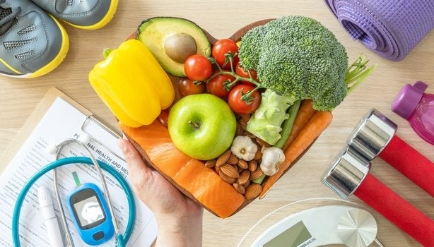 Cesta em formato de coração com alimentos saudáveis, entre itens fitness e médicos, representando diabetes.