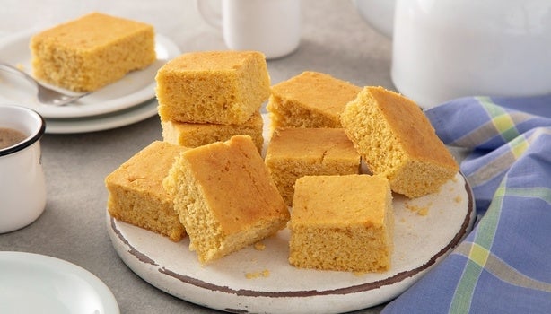 Imagem de um prato com pedaços quadrados de bolo de fubá sem glúten.