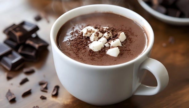 Imagem de uma xícara branca com chocolate quente e marshmallows.