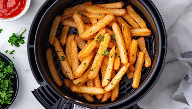 Imagem de batatas fritas em um cesto de air fryer.