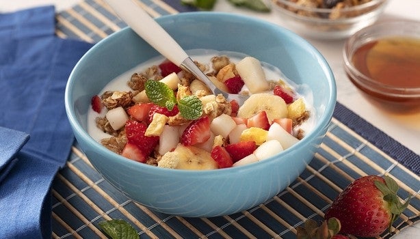 Imagem de um bowl azul claro com frutas variadas e iogurte.
